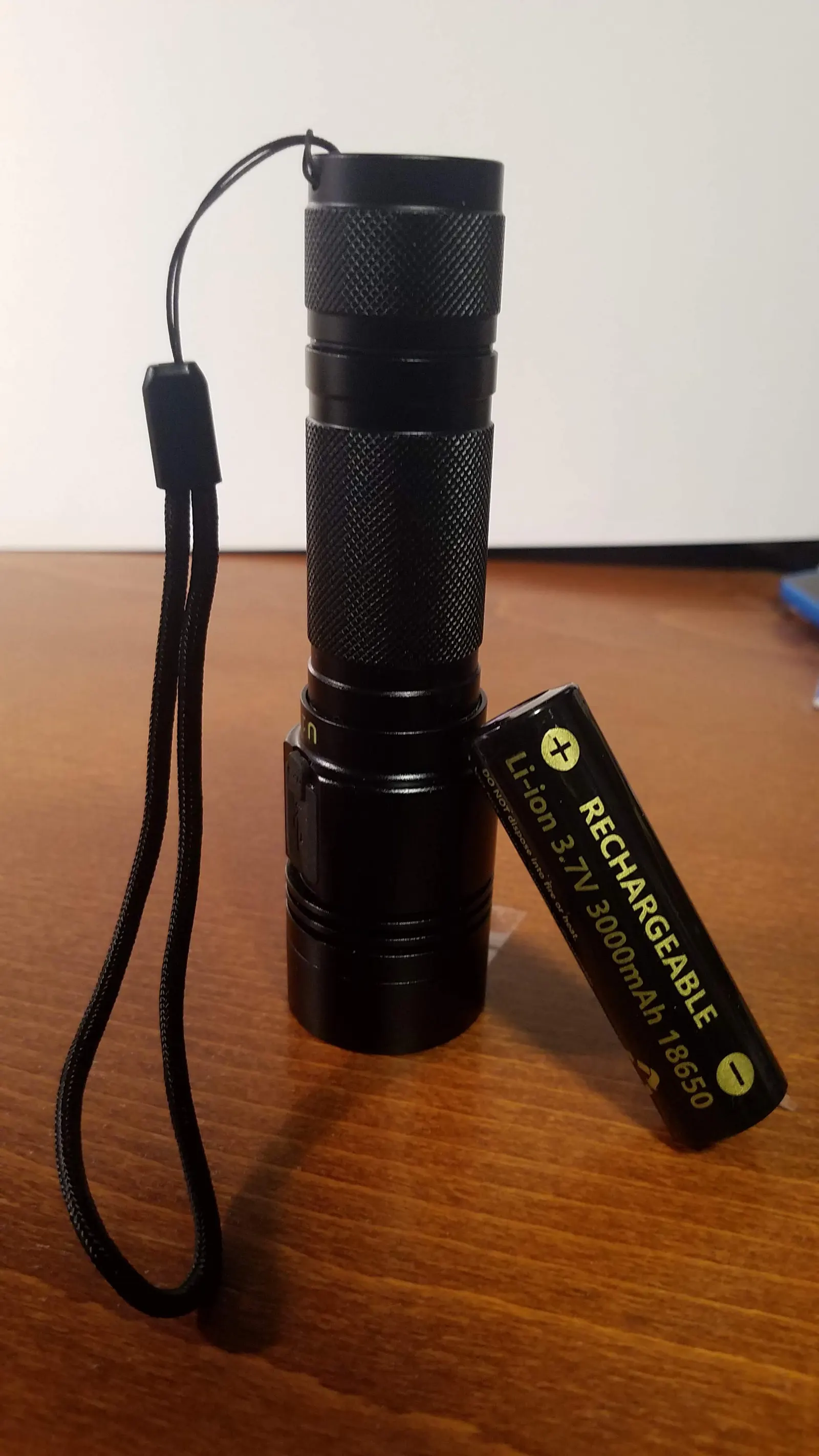 Celda 18650 junto a una linterna