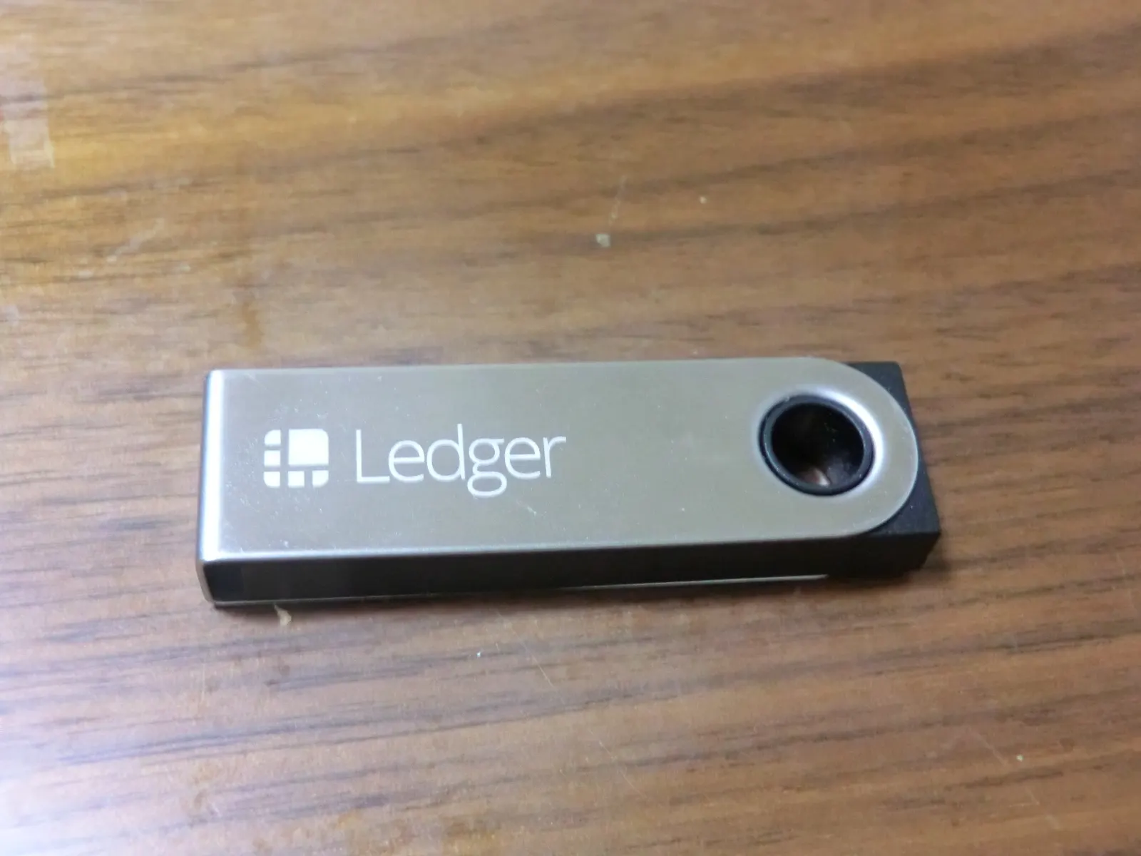 Billetera física Ledger Nano S sobre una mesa de madera