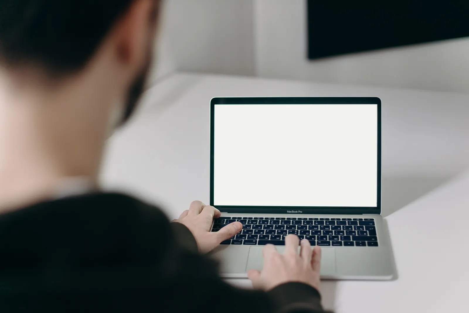 Persona frente a una computadora portátil con la pantalla en blanco